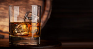 A glass of whiskey on the rocks, with large ice cubes.