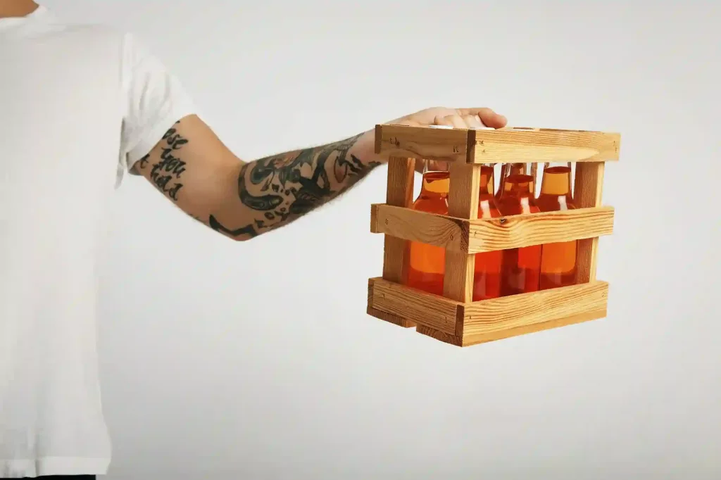 Delivery person holding a wooden crate with six bottles of craft cider, symbolizing fast and efficient service