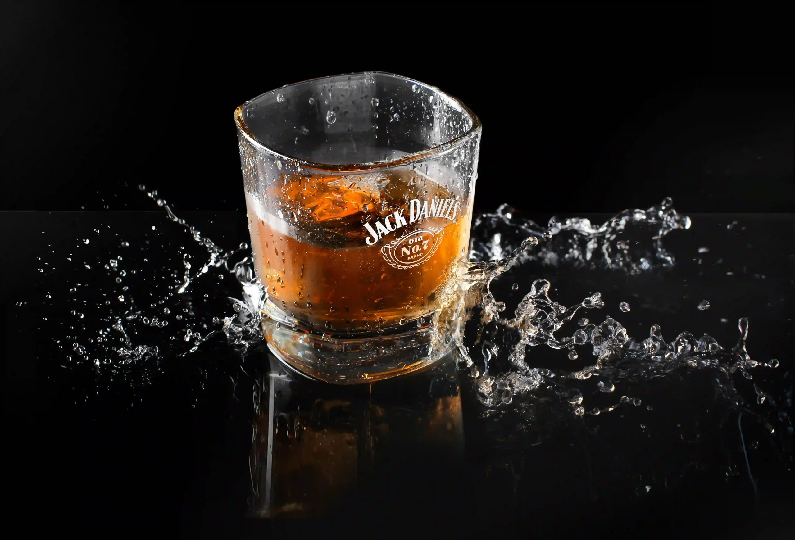 A Jack Daniel's glass with whiskey splashing, symbolizing premium alcohol delivery services by Liquor to Go GTA.
